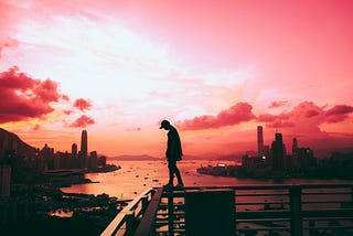 Man standing on edge of building in Hong Kong.