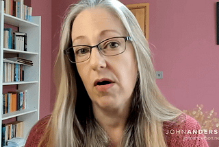 Helen Joyce is a white woman with long platinum hair and glasses. A still from the video interview.