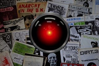 A collection of punk zines with the glaring eye of HAL 9000 from Kubrick’s ‘2001: A Space Odyssey’ in the center of the image. Image: Cryteria (modified) https://commons.wikimedia.org/wiki/File:HAL9000.svg CC BY 3.0 https://creativecommons.org/licenses/by/3.0/deed.en — Jake (modified) https://commons.wikimedia.org/wiki/File:1970s_fanzines_(21224199545).jpg CC BY 2.0 https://creativecommons.org/licenses/by/2.0/deed.en