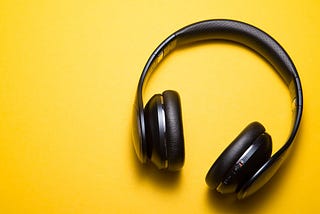 black headphones silhouetted against a bright yellow background