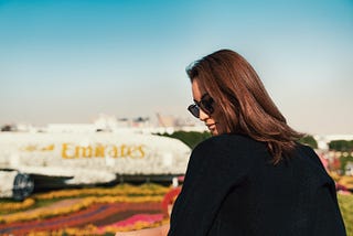 Woman in front of a floral version of the Emirates aircraft.