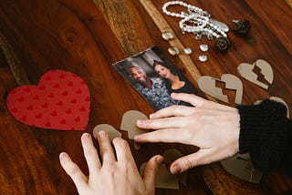 Person arranging photos and sentimental items on a table
