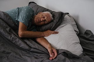 A old man sleeping on his bed