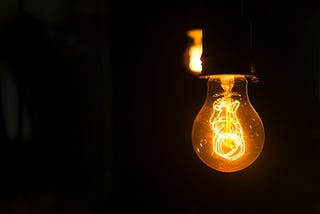 Yellow lightbulb with delicate glowing filaments.