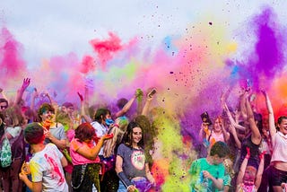 Photograph of a crowd throwing powdered colours.