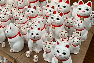 Beckoning cat statues from a shelf at Gotokuji Temple in Japan