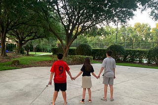 Photo of the author’s children at the park holding hands.