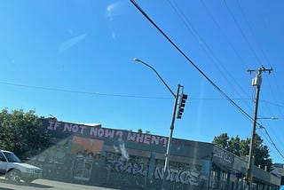 A photo of a building that sits vacant in Portland’s Kerns neighborhood, with graffiti that reads “IF NOT NOW? WHEN?”