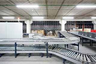 Multiple roller belts for moving boxes around a factory.