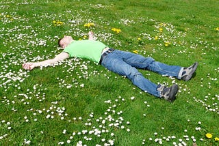 Person lying on back in a field of flowers