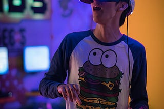 A person wearing a VR headset and a funny T-shirt looks surprised.