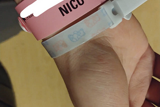 A pink NICU wrist band
