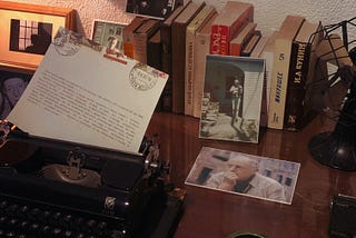 An image of a typewriter on a desk with Russian novels and documents stacked upon it