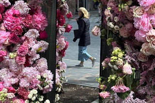 mirror reflection of a woman walking by and floral arch | © pockett dessert, blooms