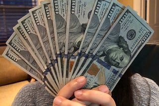 Girl Holding $100 bills