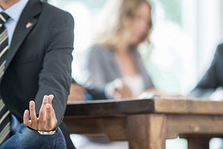 Man in a business suit in office meditating