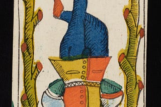 Photo of an old woodcut Tarot card image of the hanged man, a man in renaissance dress hangs upside down tied by one ankle