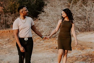 A man and a woman holding hands as they take a walk