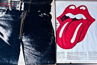 Sticky Fingers album cover from The Rolling Stones, showing a man wearing tight jeans from the waist to upper thighs on the left, and the inner sleeve on the right showing a mouth with red lips and tongue sticking out