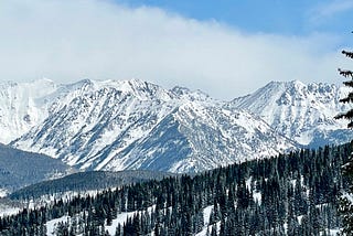 Trees, mountains, partly cloudy sky