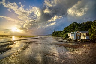 house on the beach, with a sunset