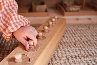 A young child using a Montessori early learning education toy.