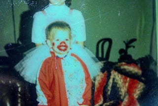 Vintage polaroid of my 7 year old sister dressed like a ballerina for Halloween standing behind me, a 2 year-old clown in a half-red/half-white clown jumper with shiny red painted mouth and nose.