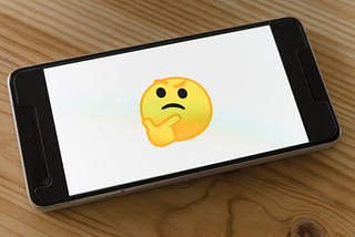 A cell phone with a white screen and an emoji. It represents “I wonder…” with an eyebrow raised and a finger on the chin.