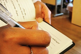Photo of acolleague’s hand while taking notes.
