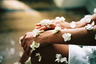 A woman is adorned in white flowers.