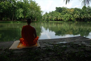 a saint is doing meditation in front of a pond