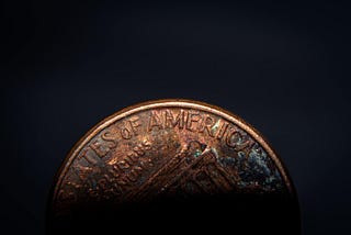old penny faded on black background, best personal finance advice