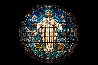 Stained glass image of Jesus with halo, dressed in white and arms open