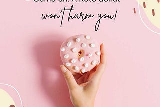 A hand holding a pink donut