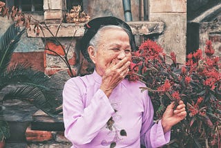An old woman laughing with her hand at her mouth inspiring wisedom