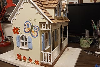 dollhouse with butterflies and flowers on the siding.