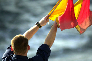 A sailor communicating with semaphore flags