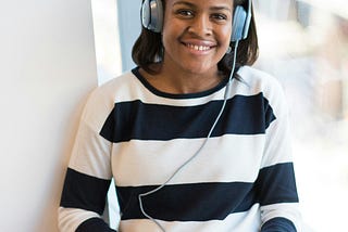 Women in black and white striped sweater using Macbook