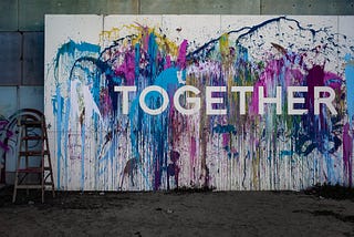 Graffiti against a colourful wall reading ‘together’