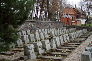 3 identical rows of identical headstones each with a cross across its center