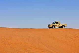 A lone truck on top of the red sand dunes of Riyadh, Saudi Arabia