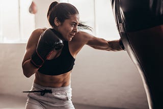 fitness woman punching a heavy bag