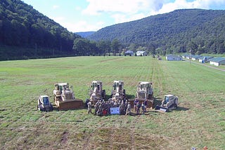 An aerial photo of a group of soldiers in a field with heavy equipment