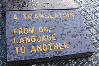 Black stone slab with an engraved phrase, “A translation from a language to another.”
