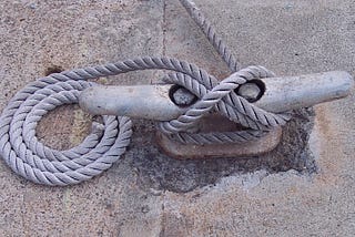 rope tied to a cleat on cement