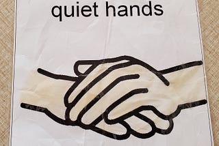 Simple drawing of a pair of hands with one on top of the other and the heading, “Quiet Hands.”