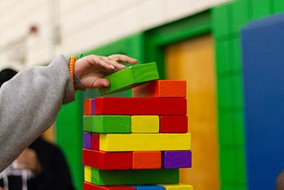 A child stacking colorful blocks. Image added in the context of affordable childcare as a necessity for gender equality