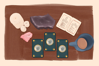 Digital illustration — a wooden desk topped with three cream pillar candles, a wedges of amethyst and rose quartz, three face down tarot cards, a notebook and a mug of tea. Illustration by the author.