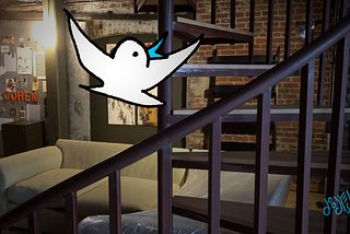 A cartoon bird flies upward in a photo of a loft with a spiral staircase. Cartoon and photo by Doodleslice 2024.