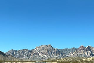 Photo by the Author. Blue sky, and the road between the mountains of Nevada
